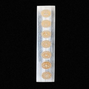 Placa/regla de Selenita rectangular con los símbolos grabados de los chakras en los colores naranja y blanco.